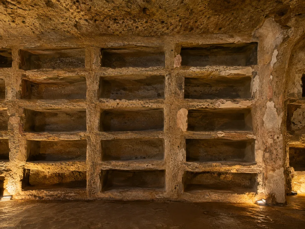 Empty burial niches cut in rows into the tufo wall of a catacomb gallery